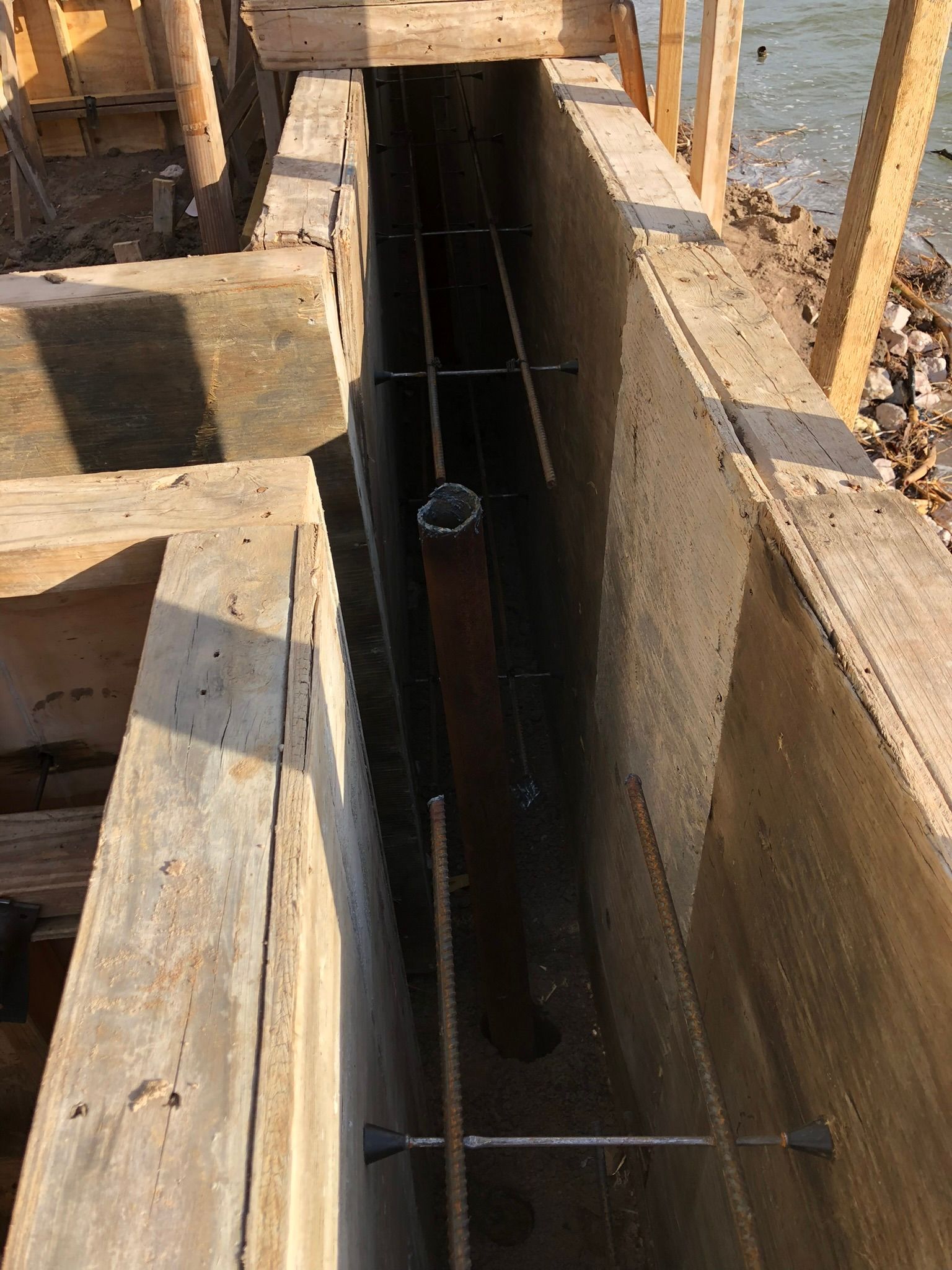 A concrete wall with a pipe in the middle of it.