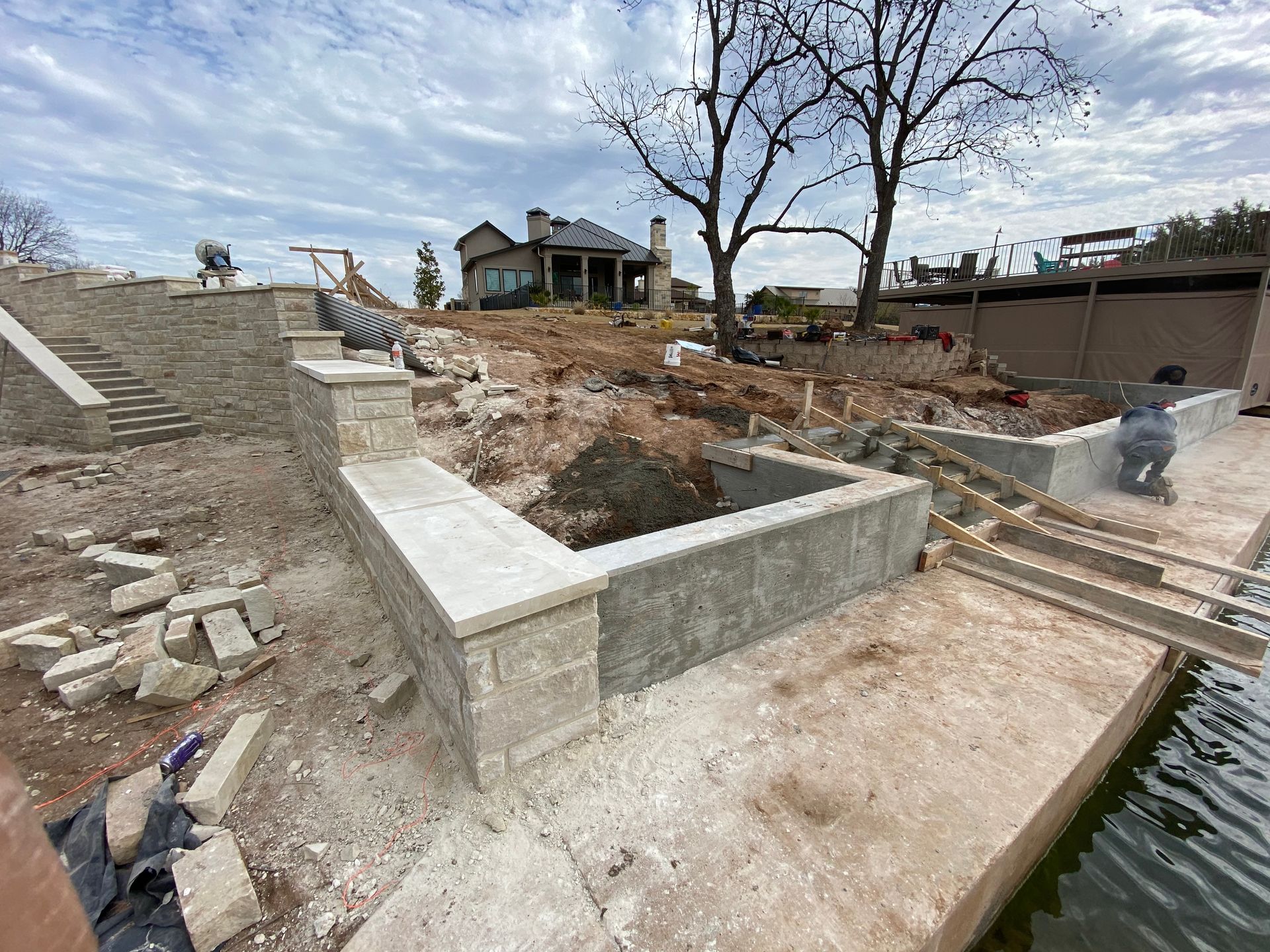 A house is being built next to a body of water.