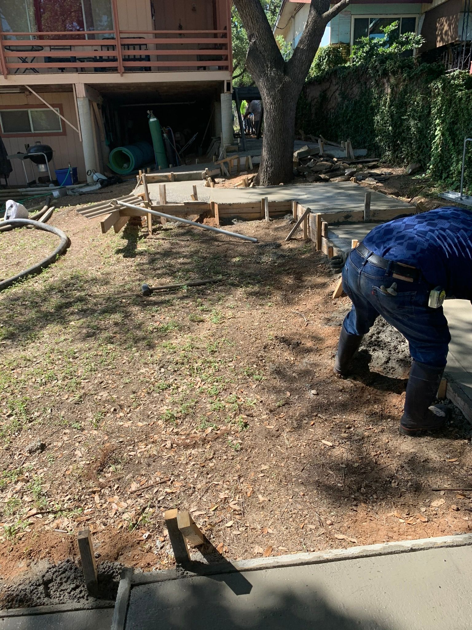 A man is digging in the dirt in front of a house.
