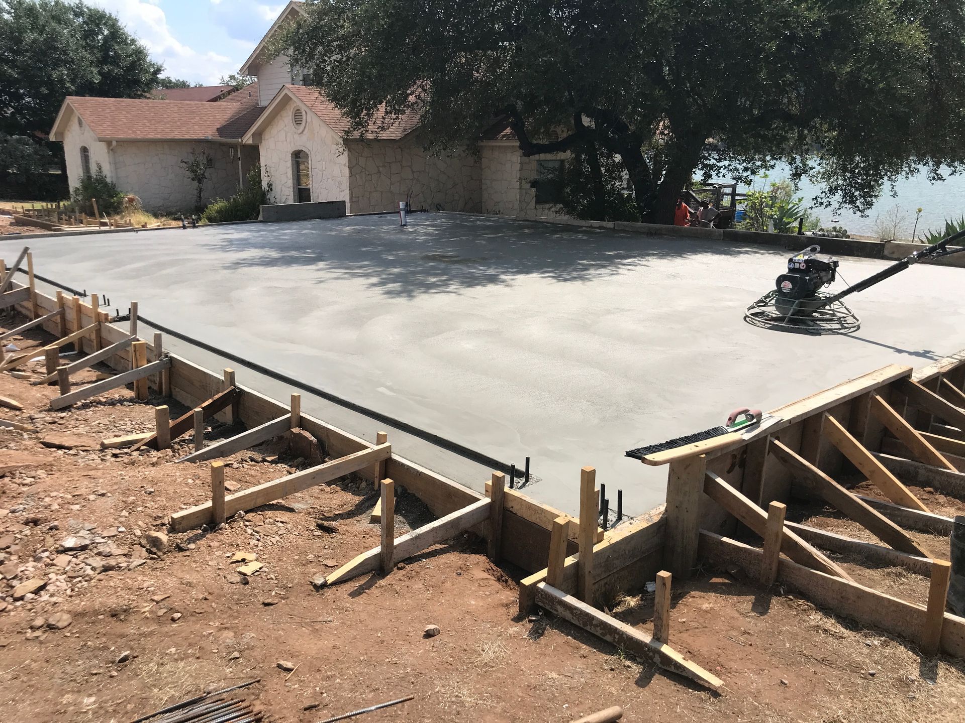 A concrete driveway is being built in front of a house