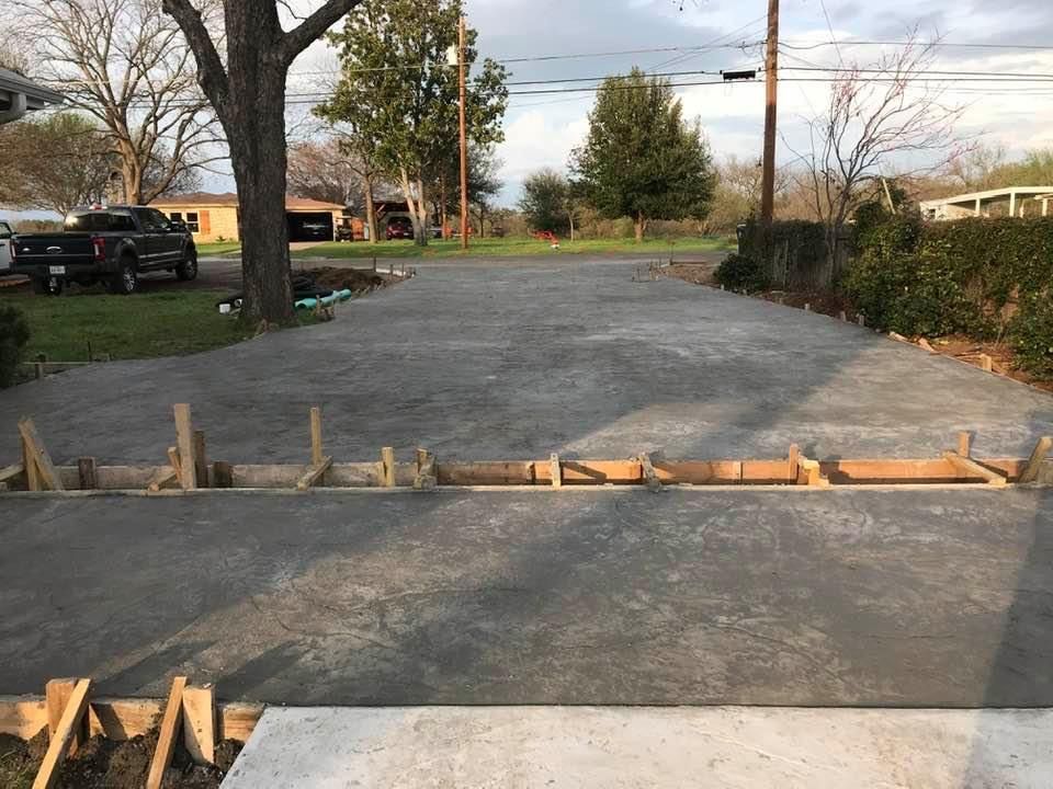 A concrete driveway is being built in a residential area.