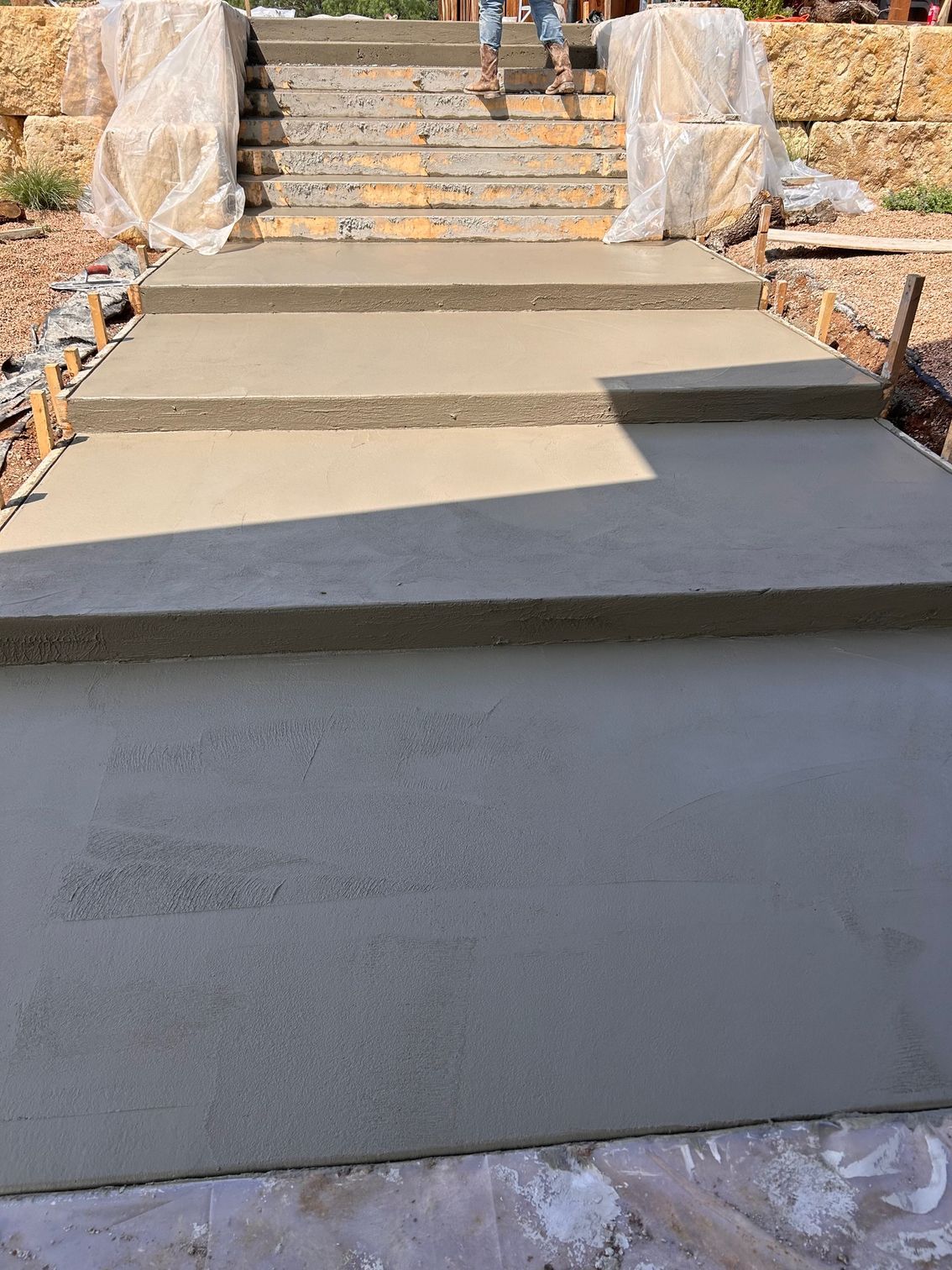 A person is walking down a set of concrete stairs.