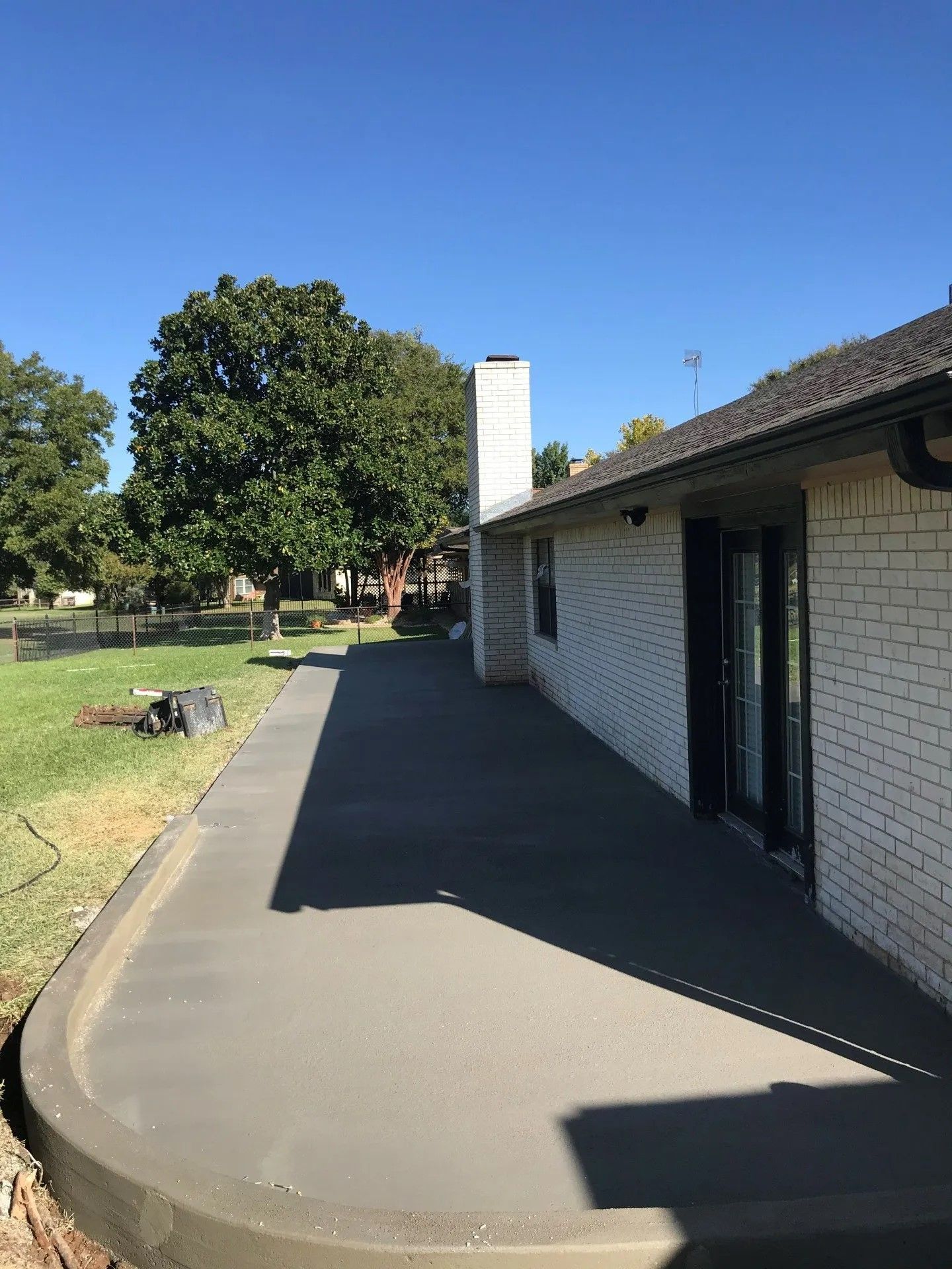 A brick house with a concrete walkway leading to it.