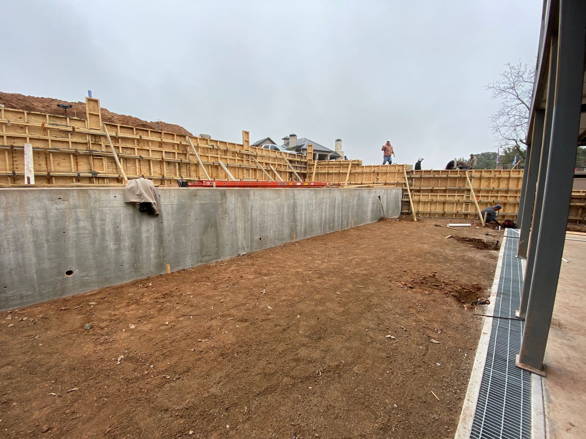 A concrete wall is being built next to a dirt field.