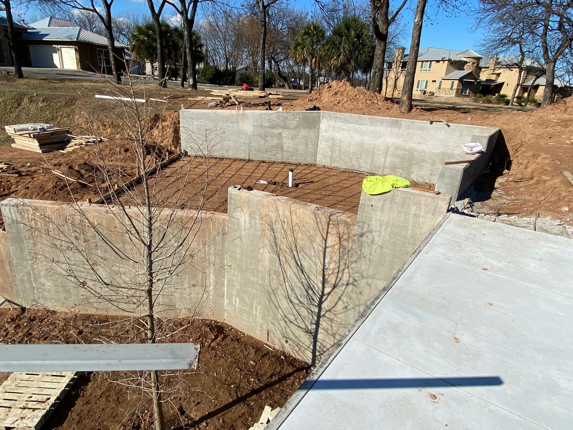 A concrete wall is being built in the middle of a dirt field