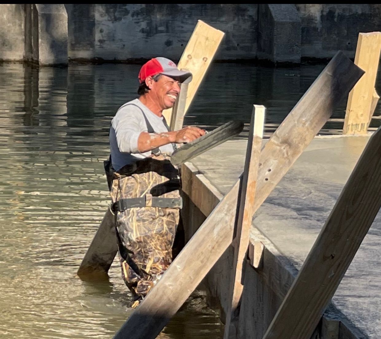 A man in waders is standing in a body of water