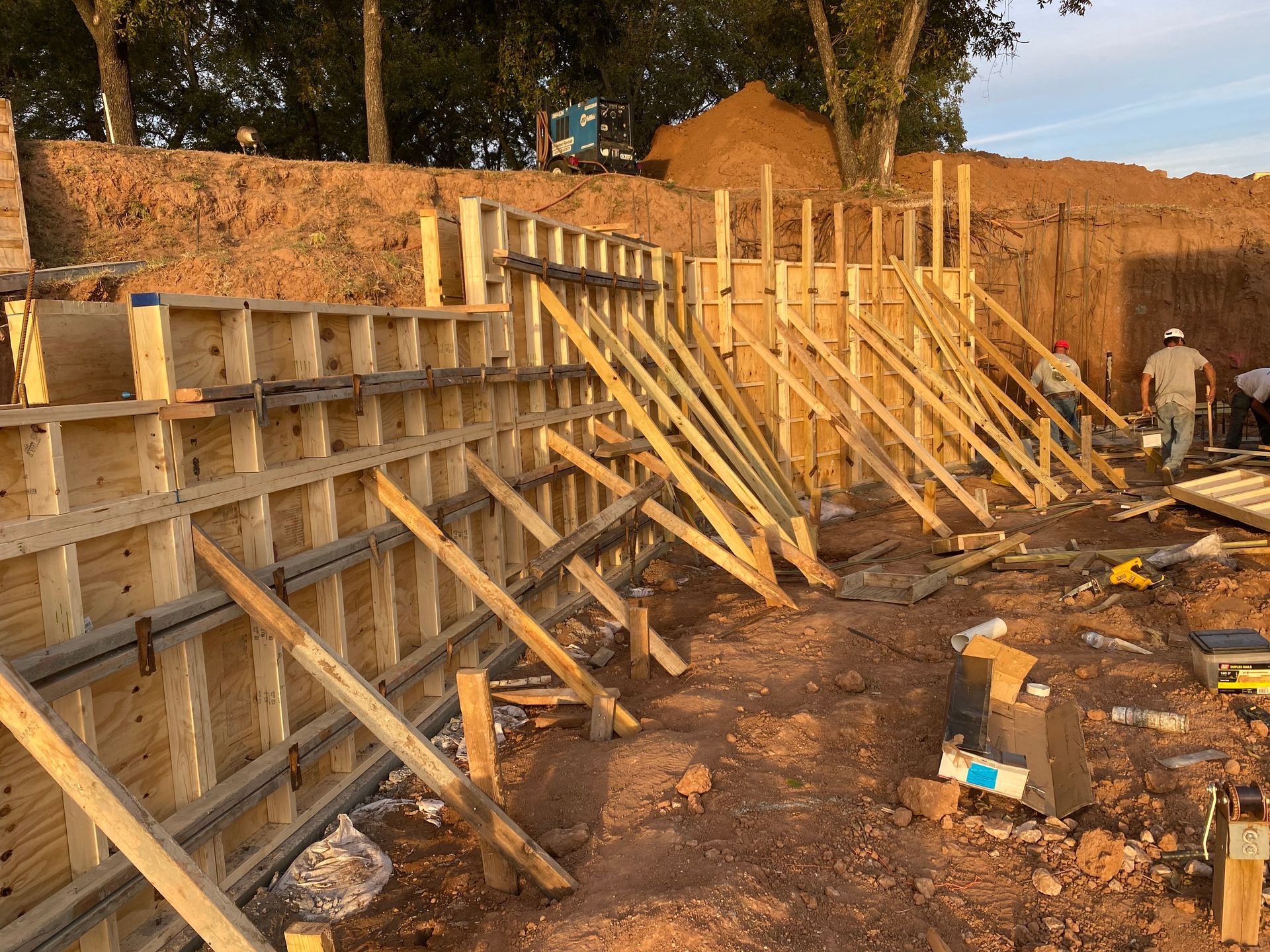 A large wooden wall is being built in the dirt.