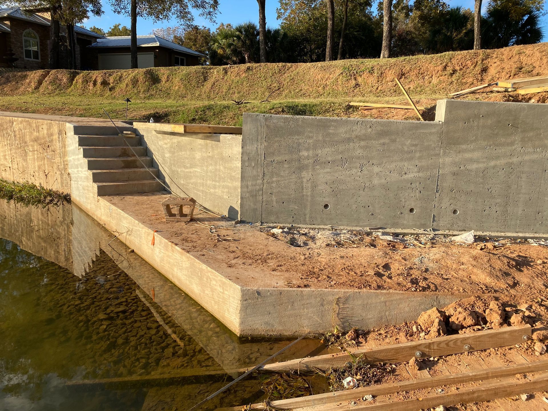 A concrete wall is being built next to a body of water
