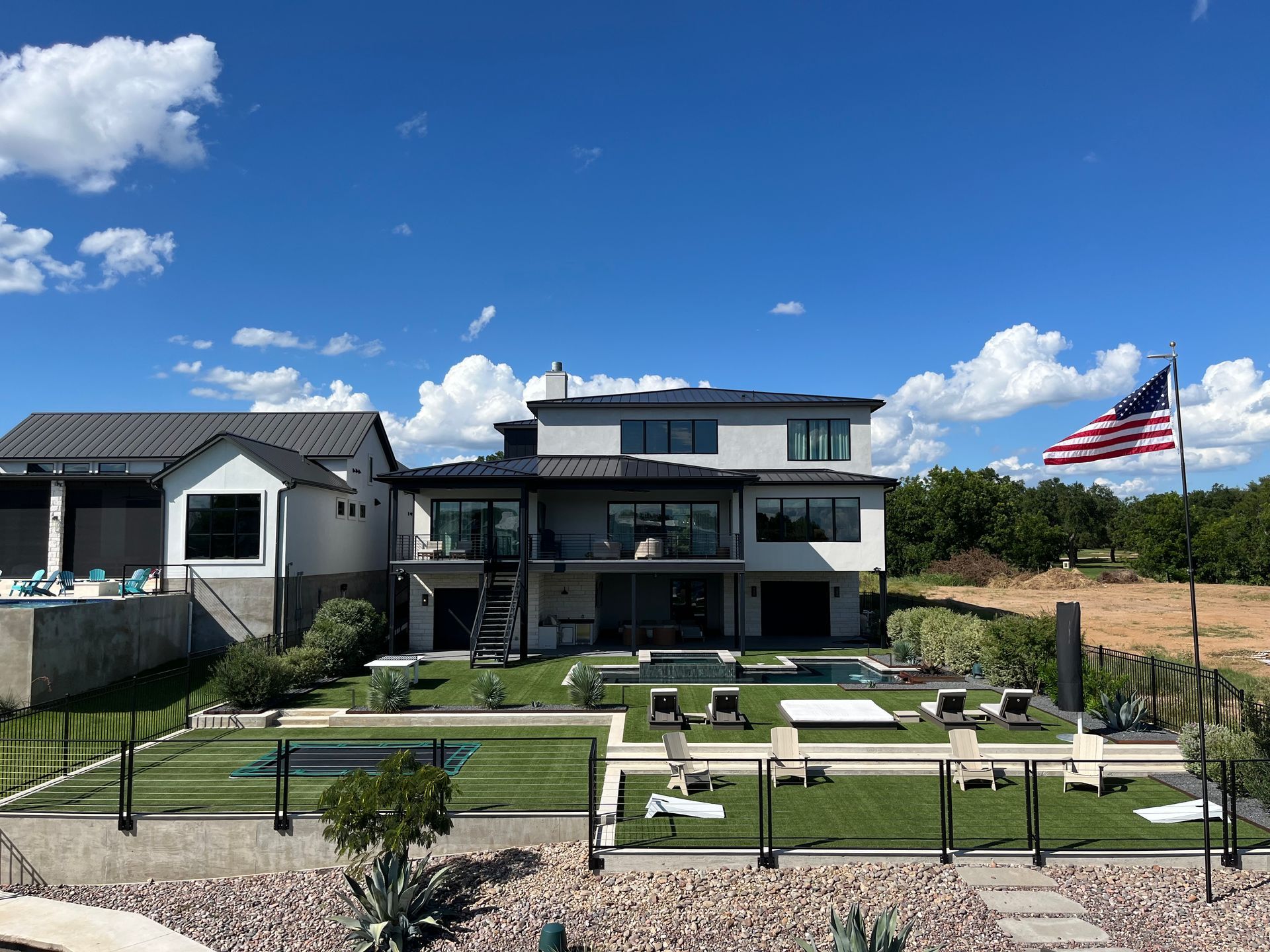 A large house with a pool and an american flag in front of it