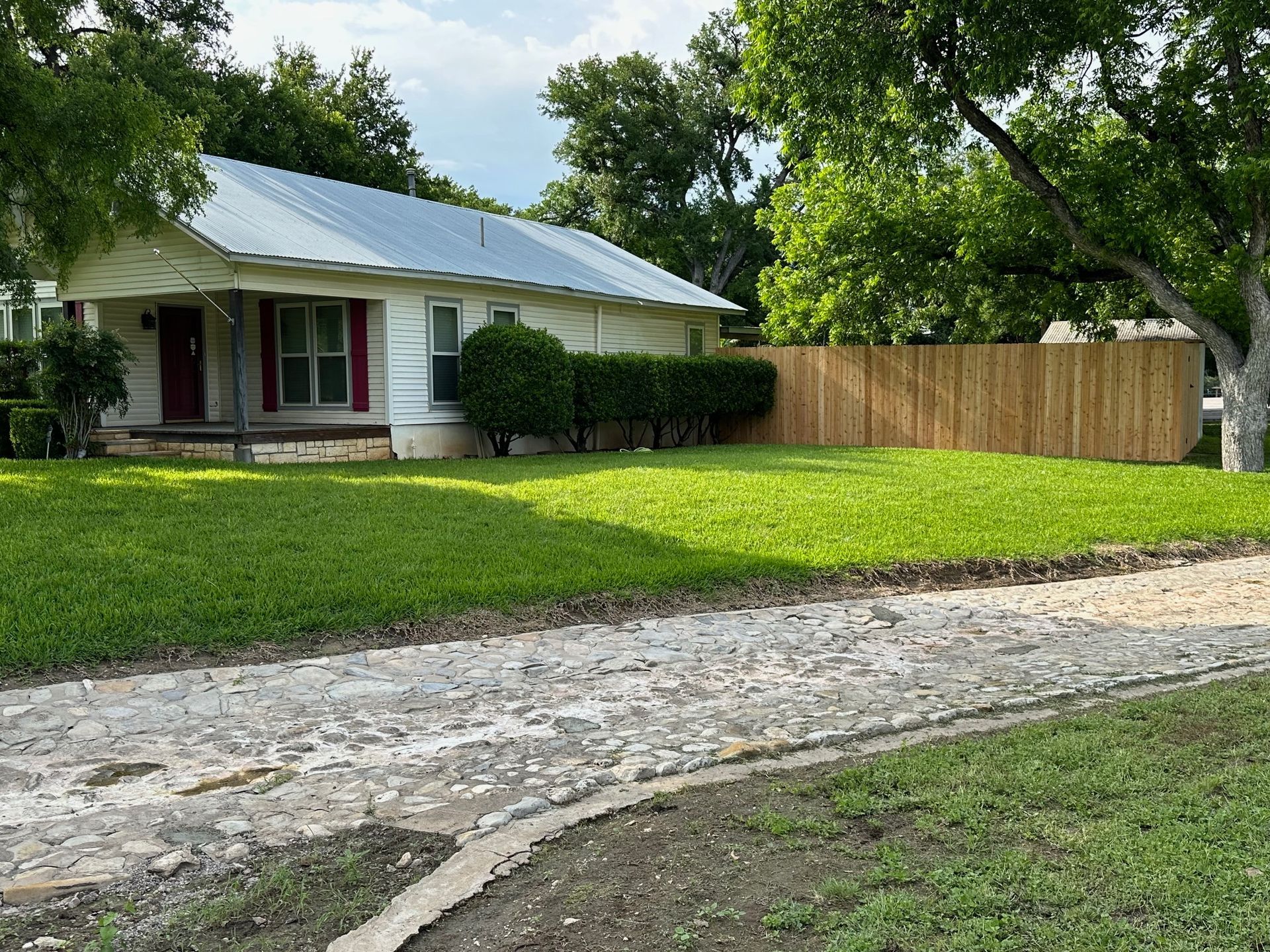 A white house with a wooden fence in front of it