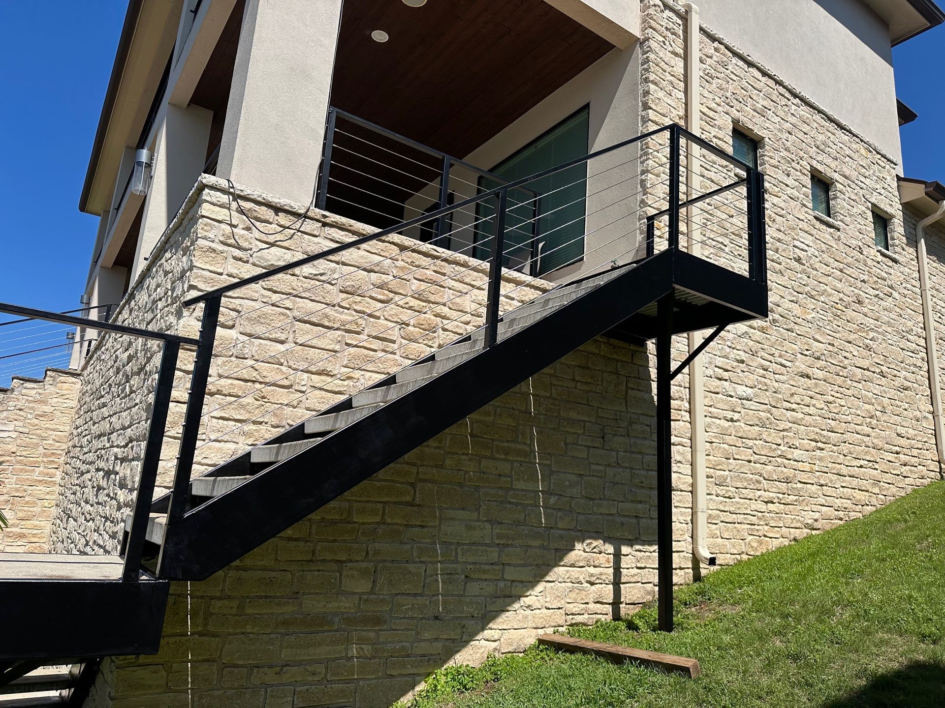 A set of stairs leading up to a balcony on the side of a house.