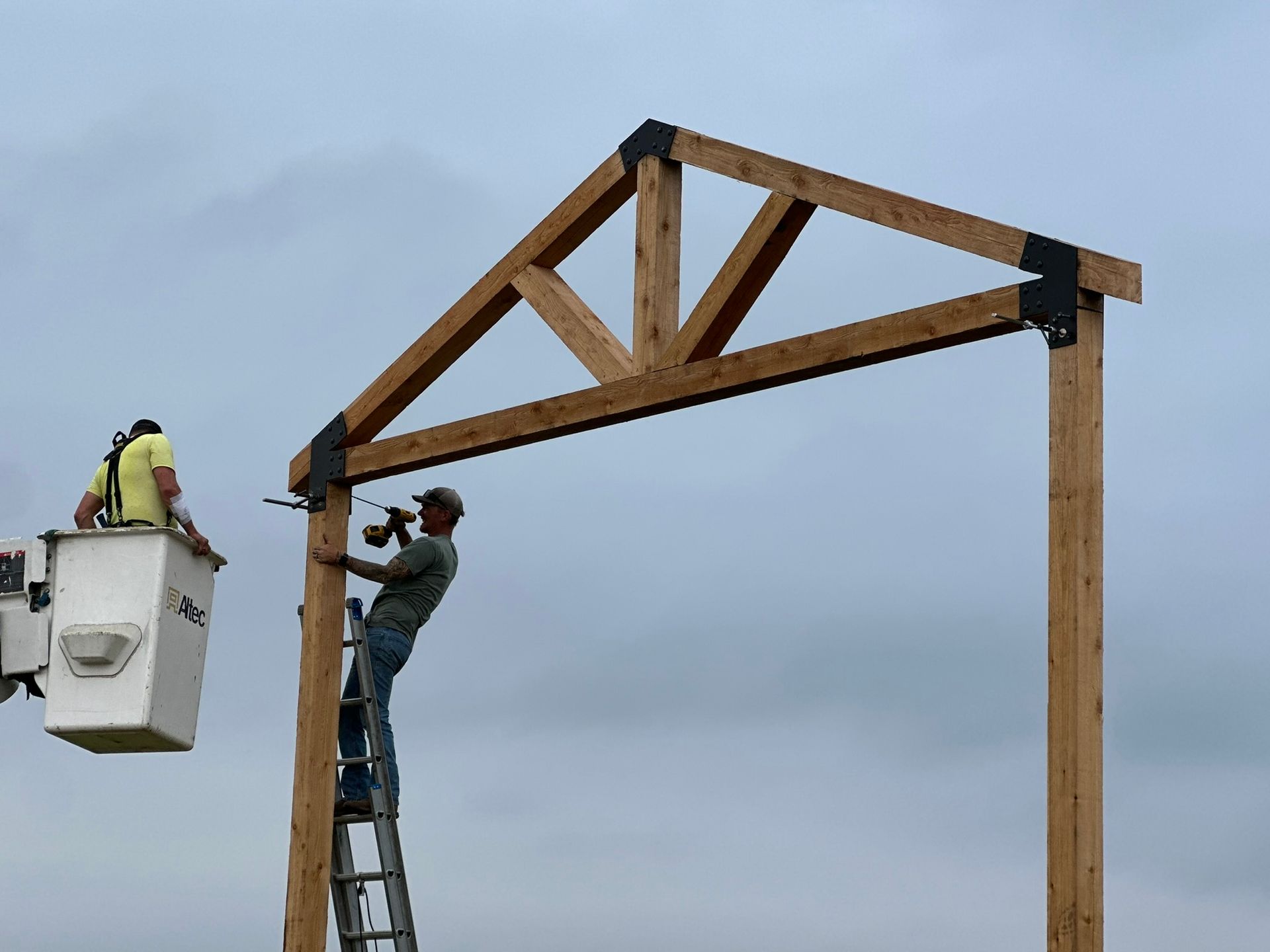 Two men are working on a wooden structure.