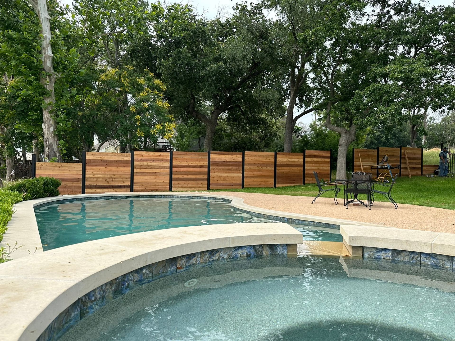 A large swimming pool with a wooden fence surrounding it.