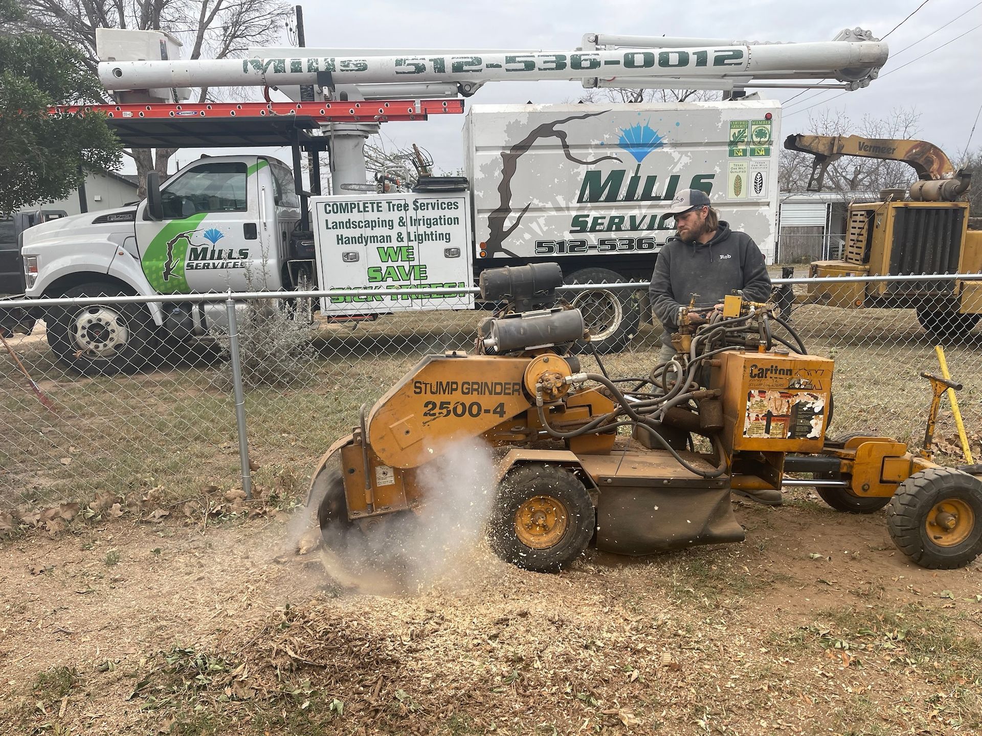 A man is using a stump grinder to remove a tree stump.