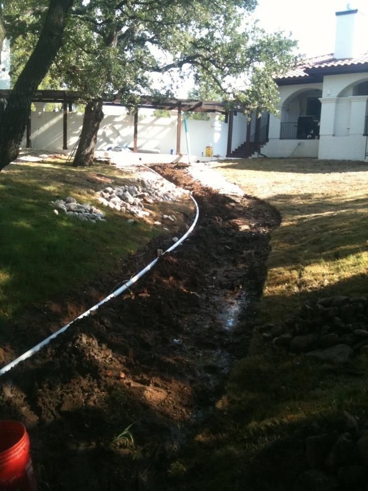 A hose is laying in the dirt in front of a house