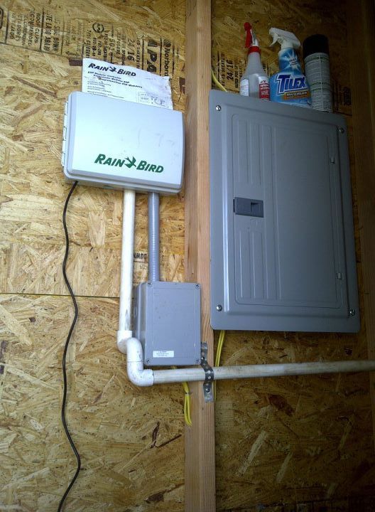 There is a box on the wall that says rainbird on it.