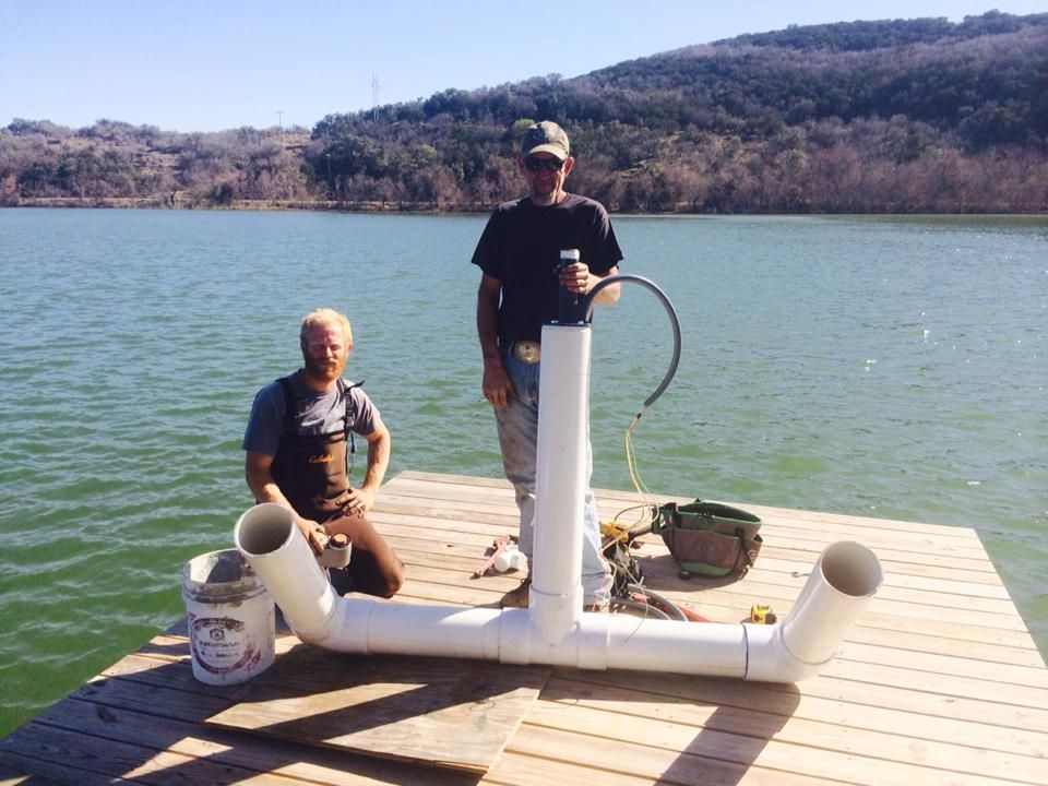 Two men are standing on a dock near a lake