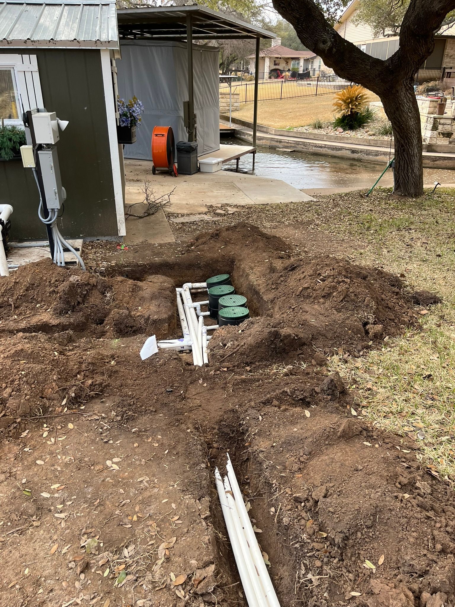 A drainage system is being installed in the backyard of a house.