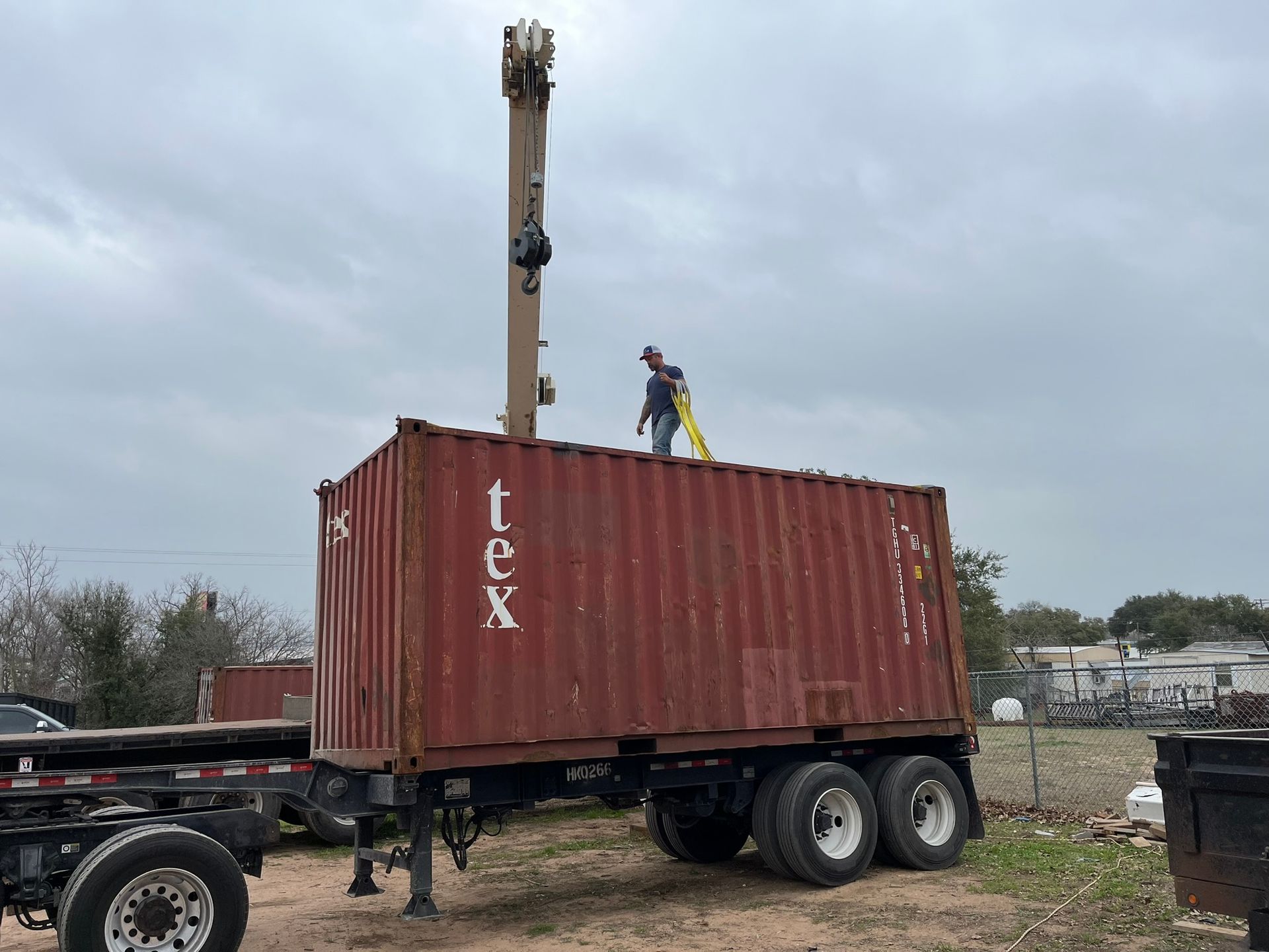 A man is standing on top of a red shipping container.