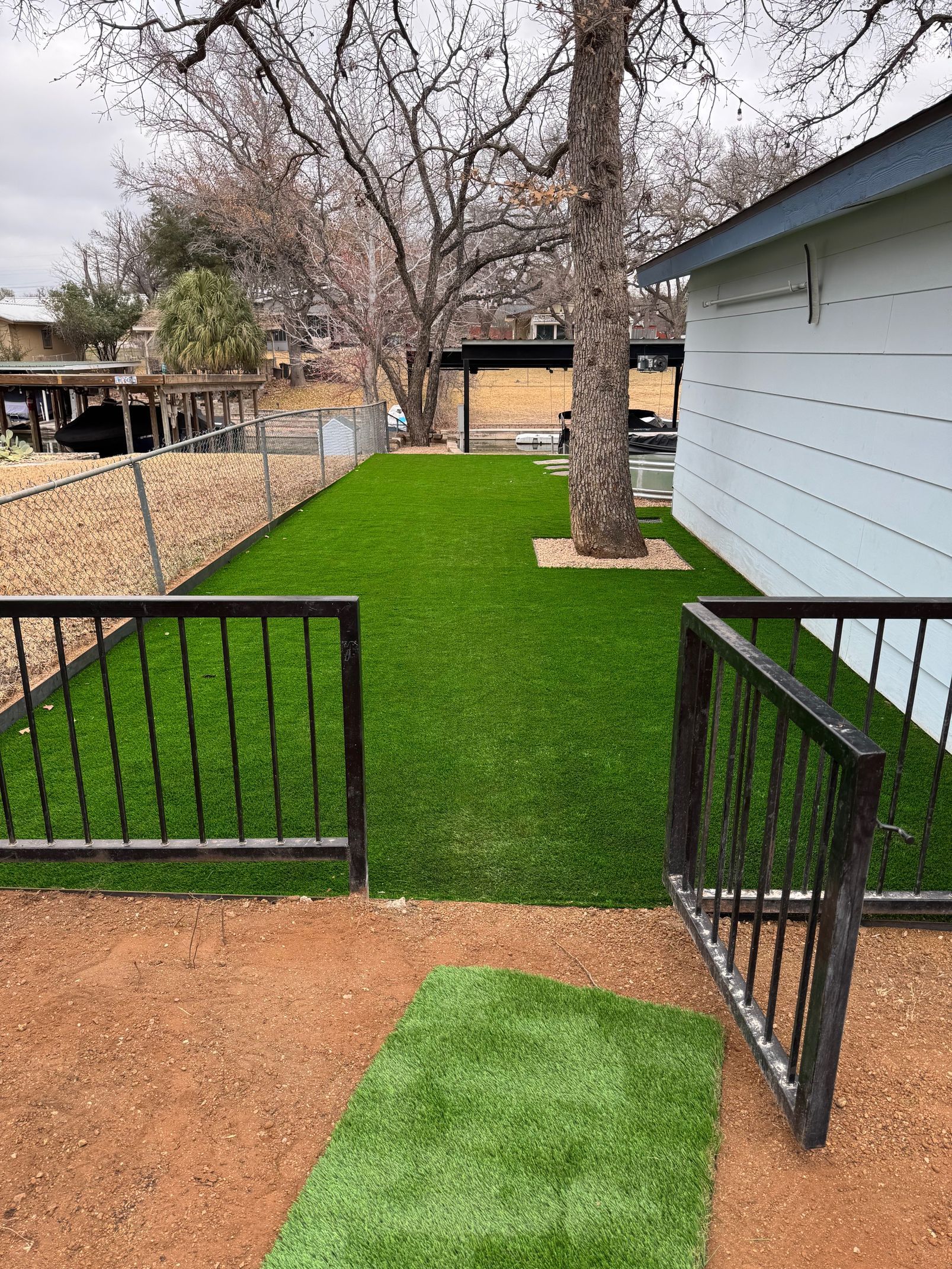 A house with a fence and a lush green lawn in front of it.