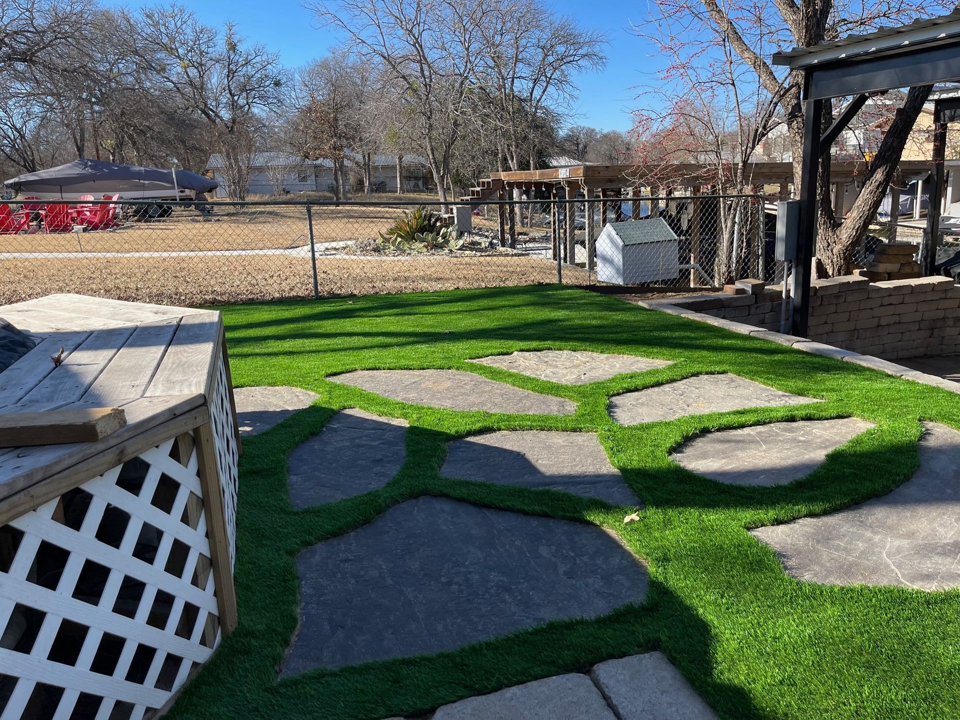 A patio with a lot of grass and stone walkways