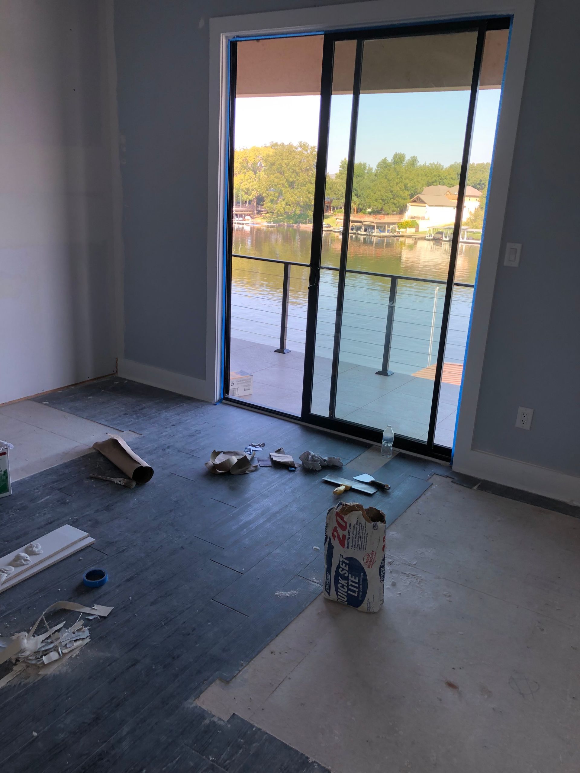 A room with a sliding glass door and a bag of paint on the floor.