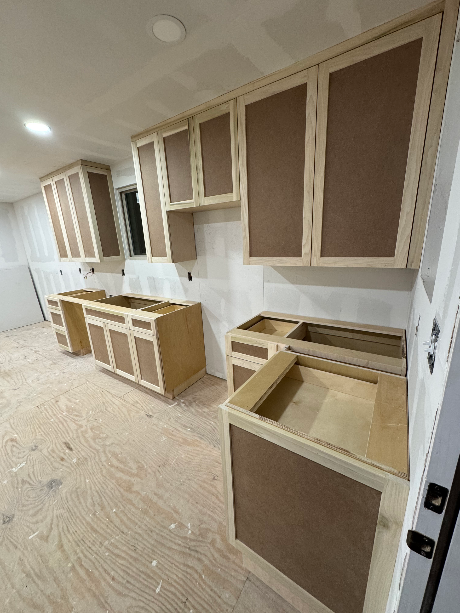 A kitchen under construction with wooden cabinets and counter tops.
