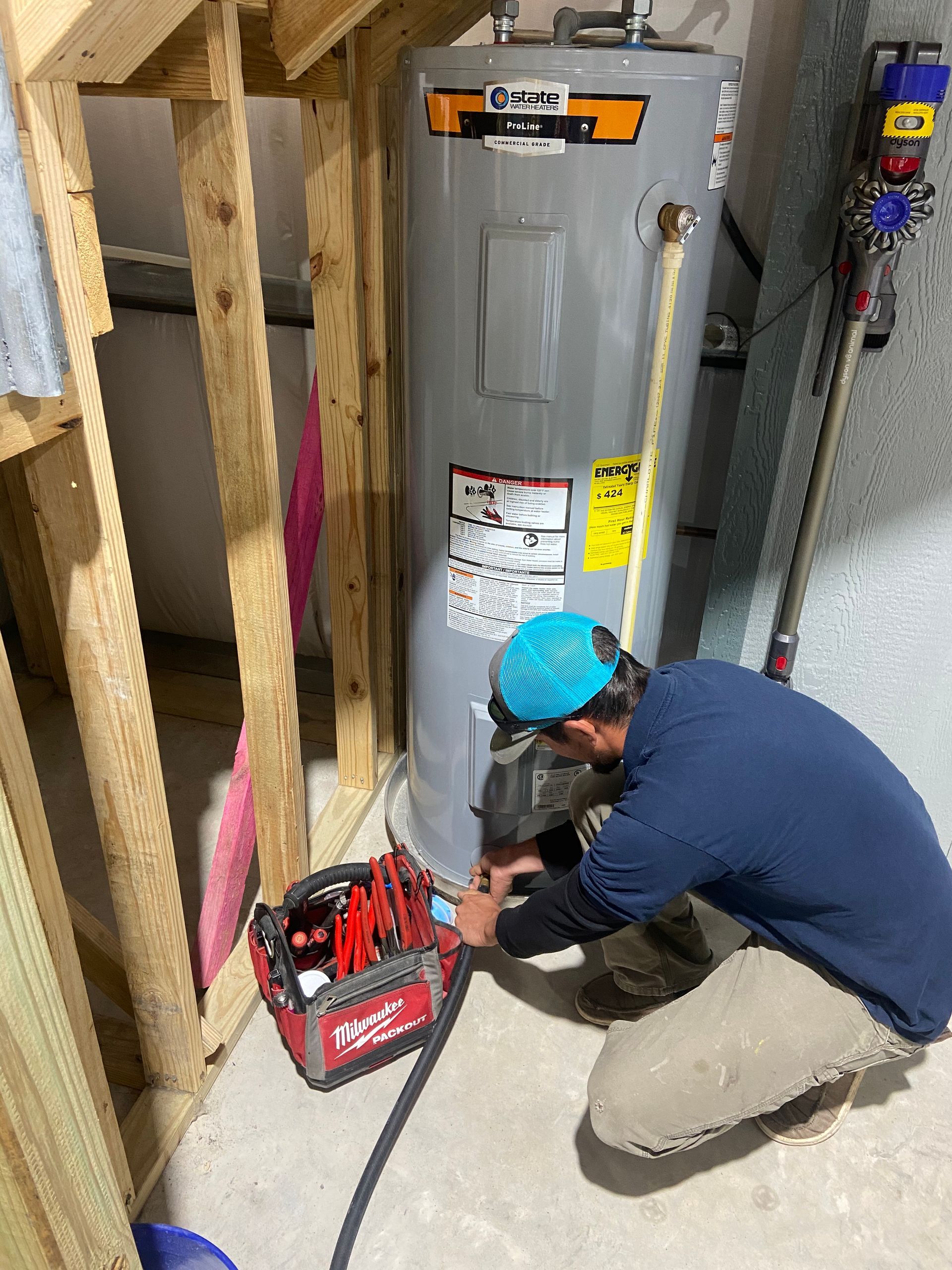 White water heater with vent pipes in a utility room.