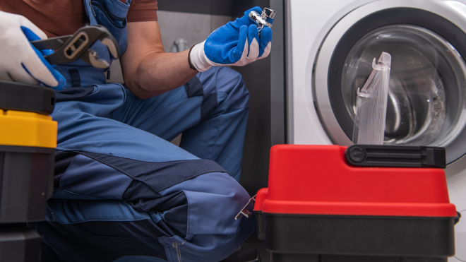 A kitchen sink with plumbing tools: a wrench, hose, and faucet.