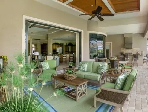 Outdoor patio with green seating, open to a living room.