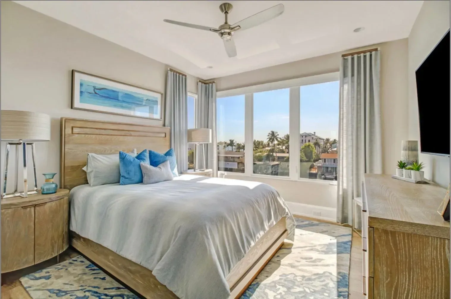 A bedroom with a large bed and a ceiling fan.