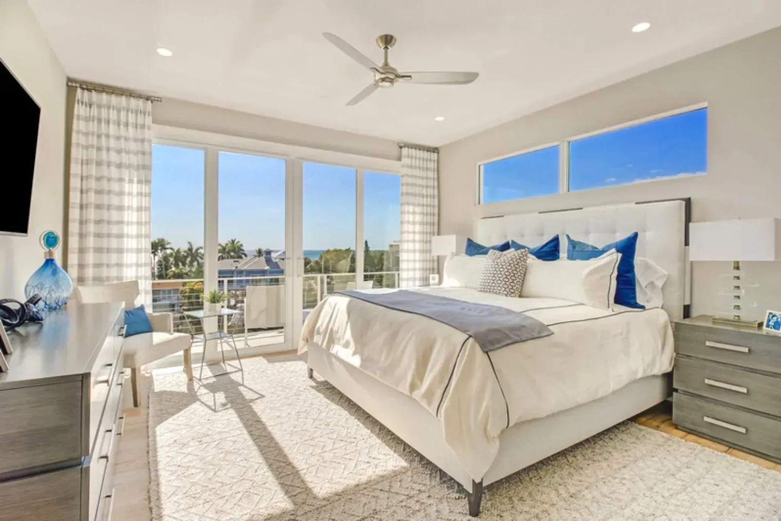 A bedroom with a large bed and a ceiling fan.
