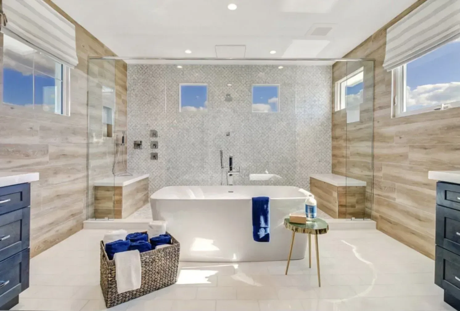Luxurious modern bathroom with a white tub, shower, and blue accents.