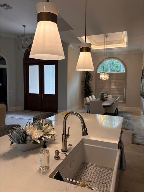 Kitchen with island, pendant lights, farmhouse sink. Dining room visible.