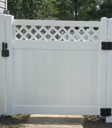 White vinyl fence gate with lattice top, black hinges, and latch.