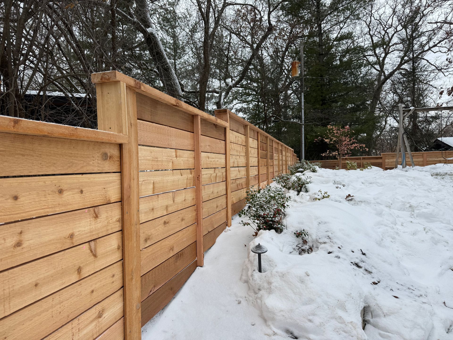 Wooden fence covered with snow, in a winter landscape.
