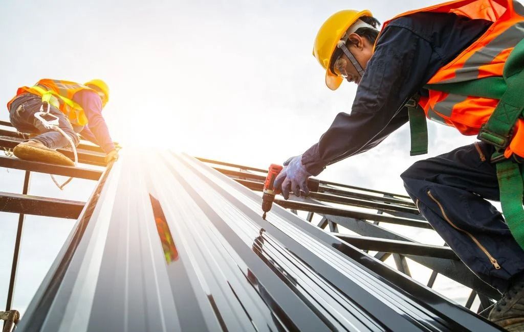 A construction worker is working on the roof of a building.