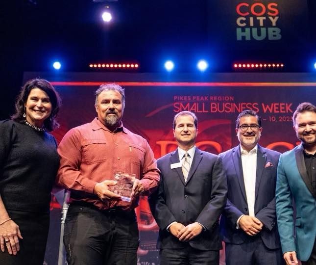 A group of people standing in front of a cos city hub sign.