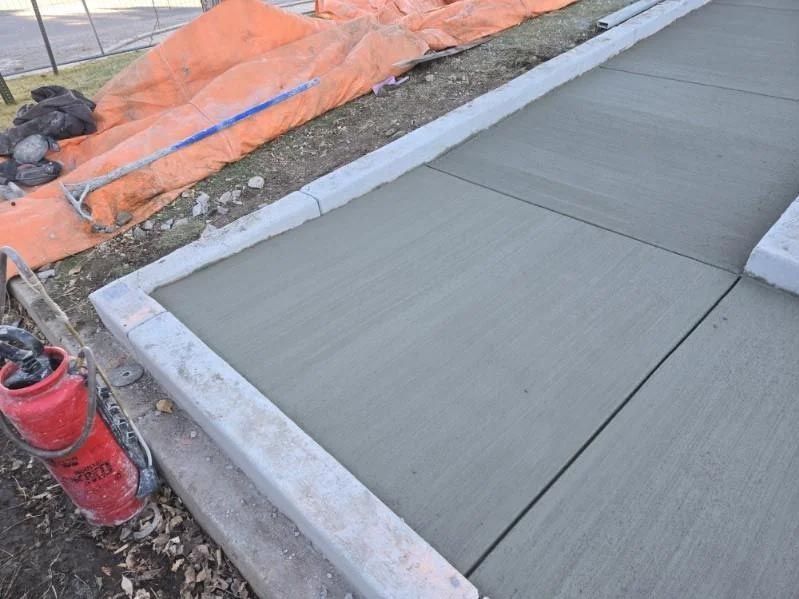 A concrete sidewalk is being built next to a fire hydrant.