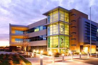 A large building with lots of windows is lit up at night