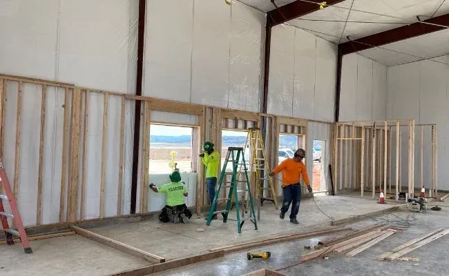 A group of construction workers are working on a building.