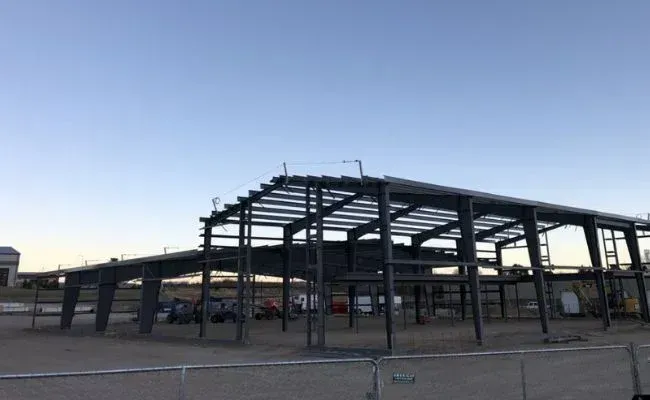 A large metal structure is being built in the desert.