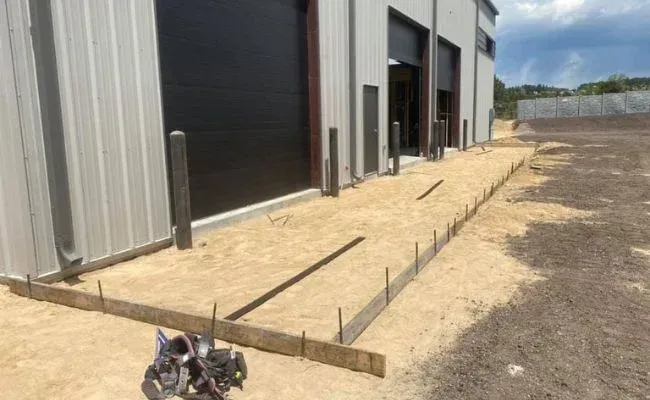 A concrete walkway is being built in front of a building.