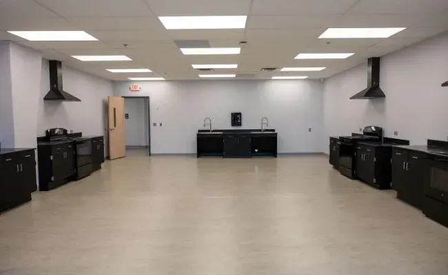A large empty room with a lot of cabinets and appliances.