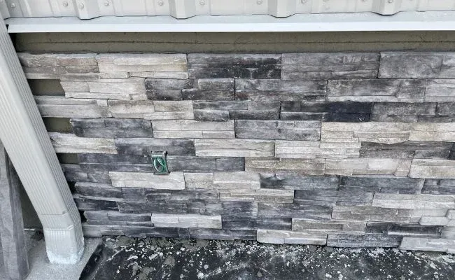 A close up of a brick wall with a white gutter.