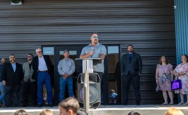 A man is standing at a podium giving a speech to a group of people.