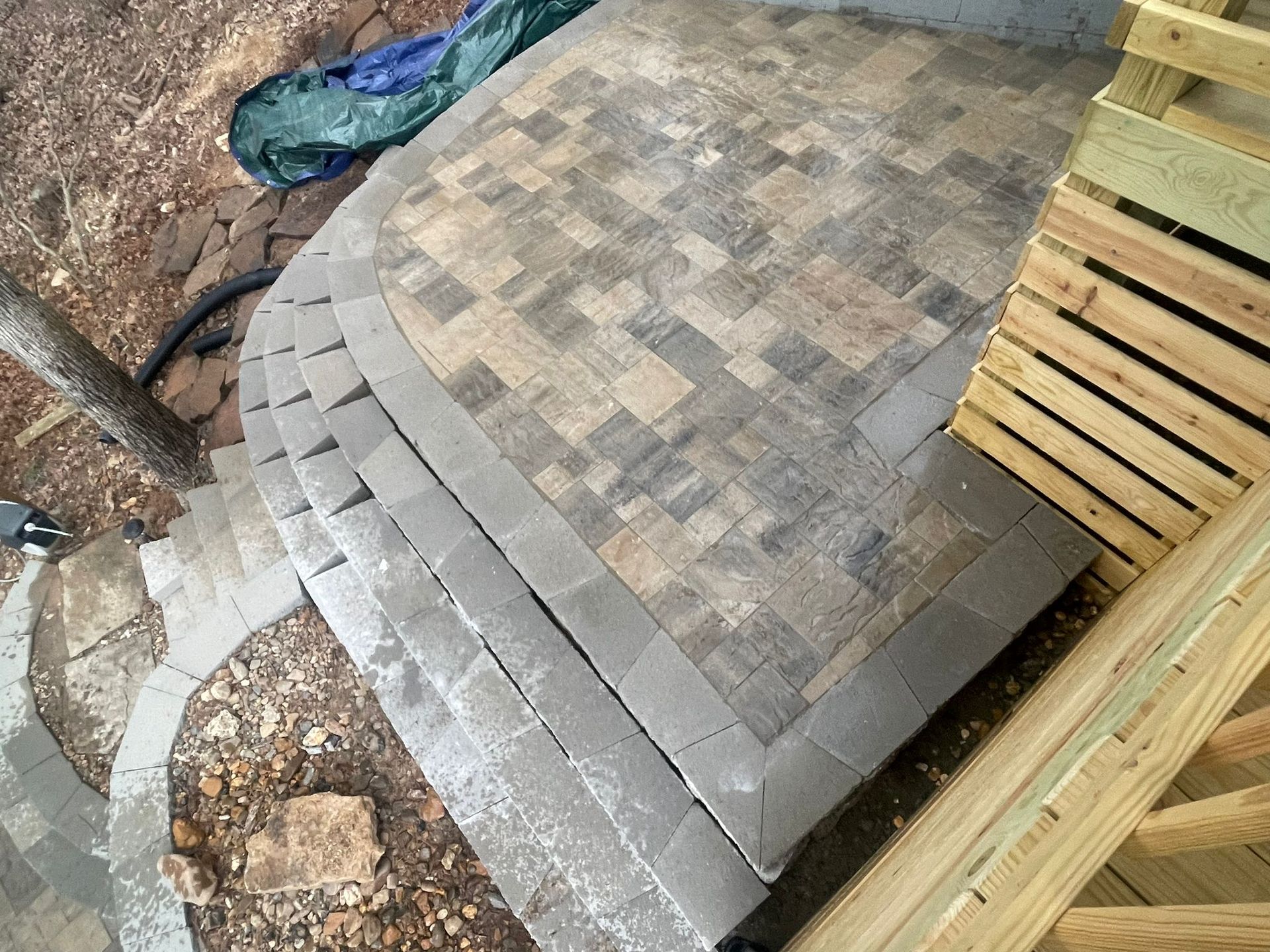 A brick walkway with steps leading up to a wooden deck.