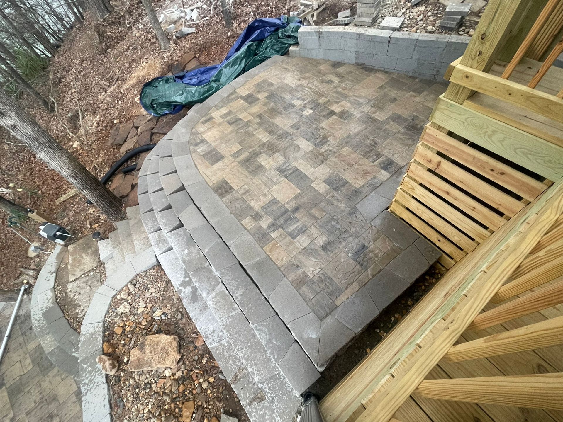 A wooden deck with stairs leading up to it is being built in the woods.