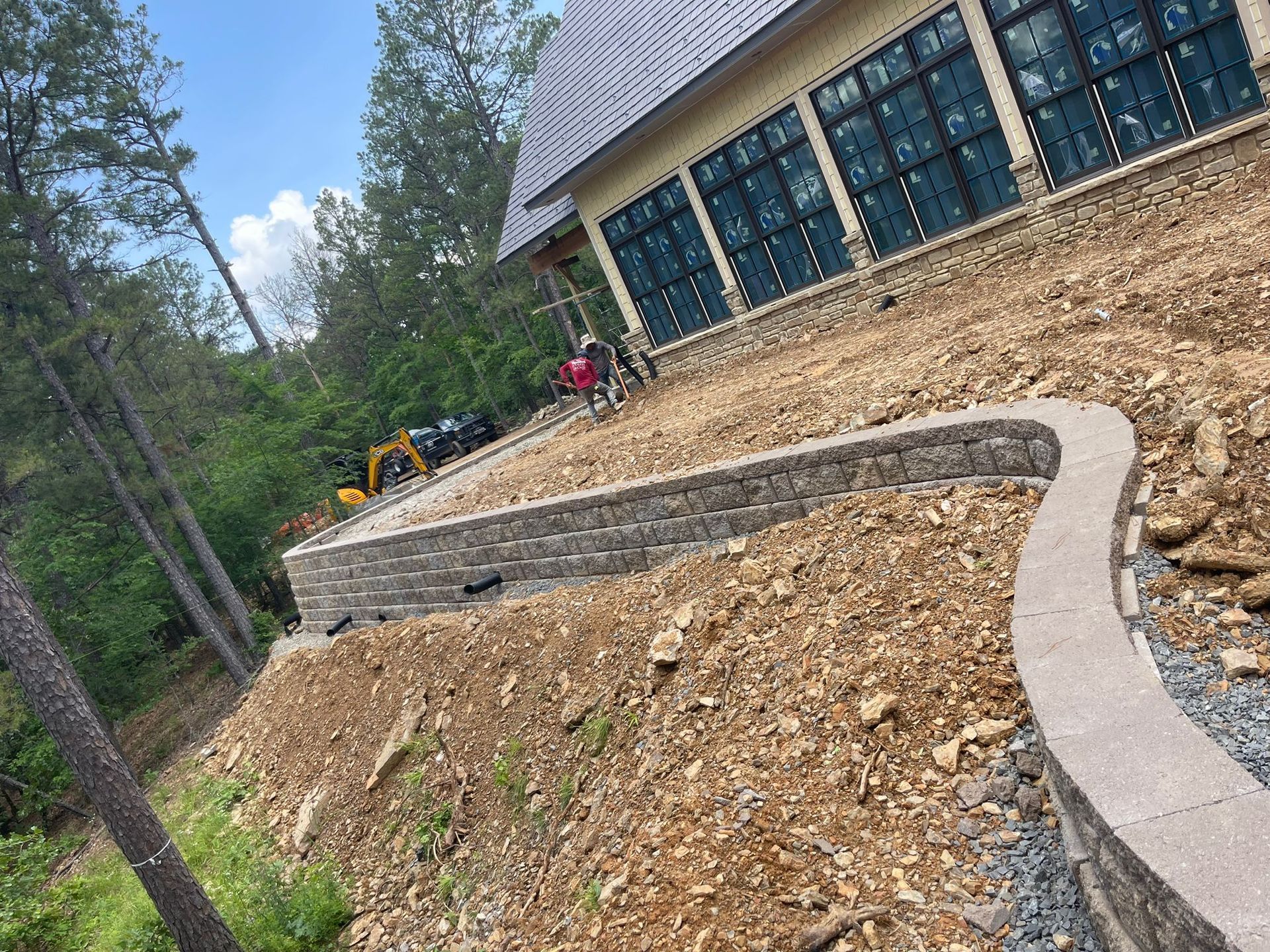 A stone wall is being built in front of a house.