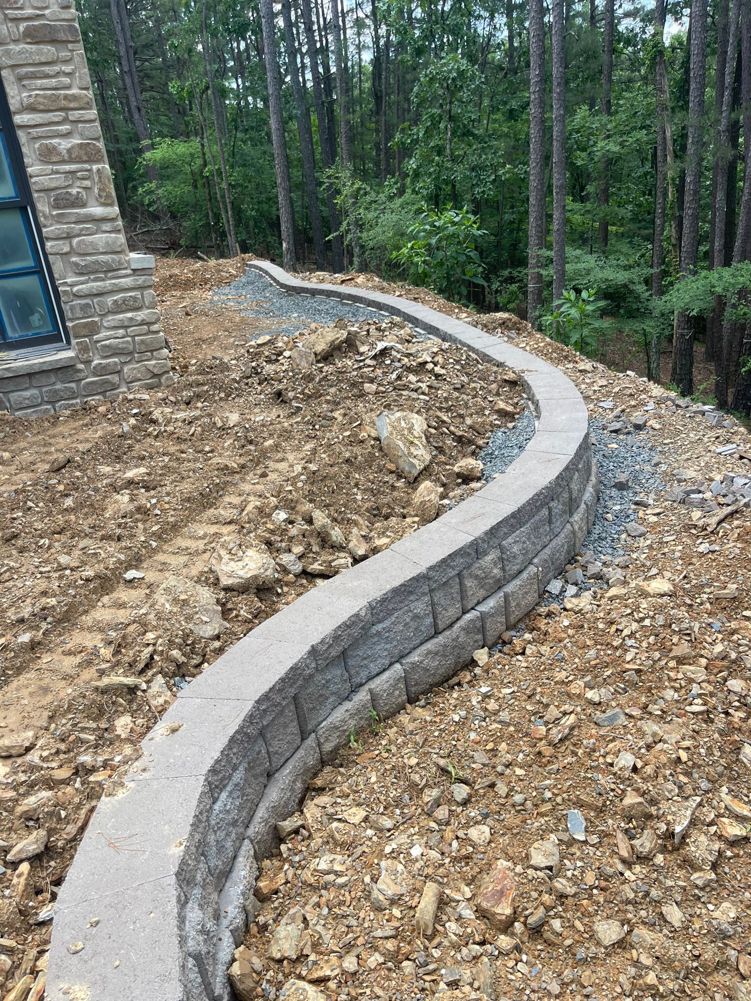 A stone wall is being built on top of a pile of gravel.